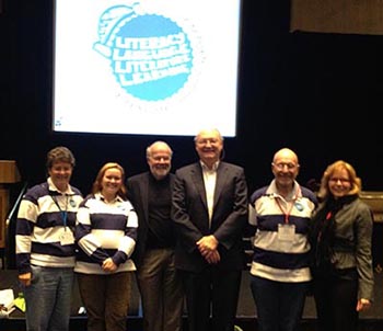 Don Leu standing with other researchers at a conference.
